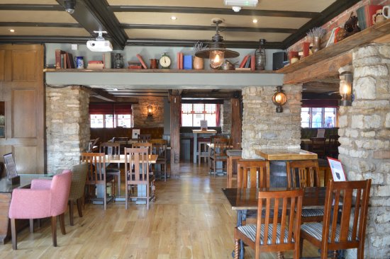Interior of The Plough Brackley Pub, showcasing rustic stone walls and cosy seating areas.
